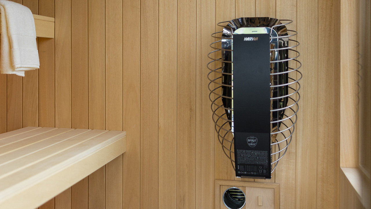 Electric heater for luxury garden sauna installed inside premium outdoor cabin with alder benches